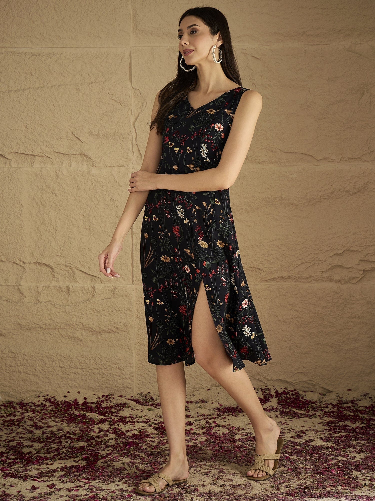 A Sleek Black Floral-Printed Knee-Length Dress With A V-Neckline And Side Slit Sleeveless, Stylish, And Perfect For Effortless Day-To-Evening Charm.