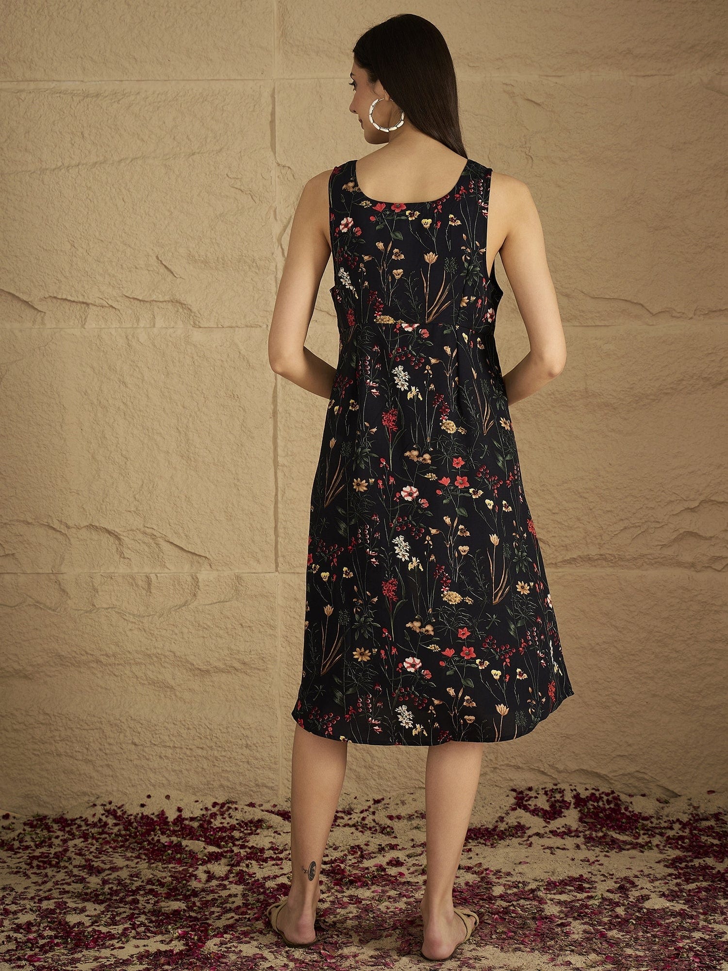 A Sleek Black Floral-Printed Knee-Length Dress With A V-Neckline And Side Slit Sleeveless, Stylish, And Perfect For Effortless Day-To-Evening Charm.