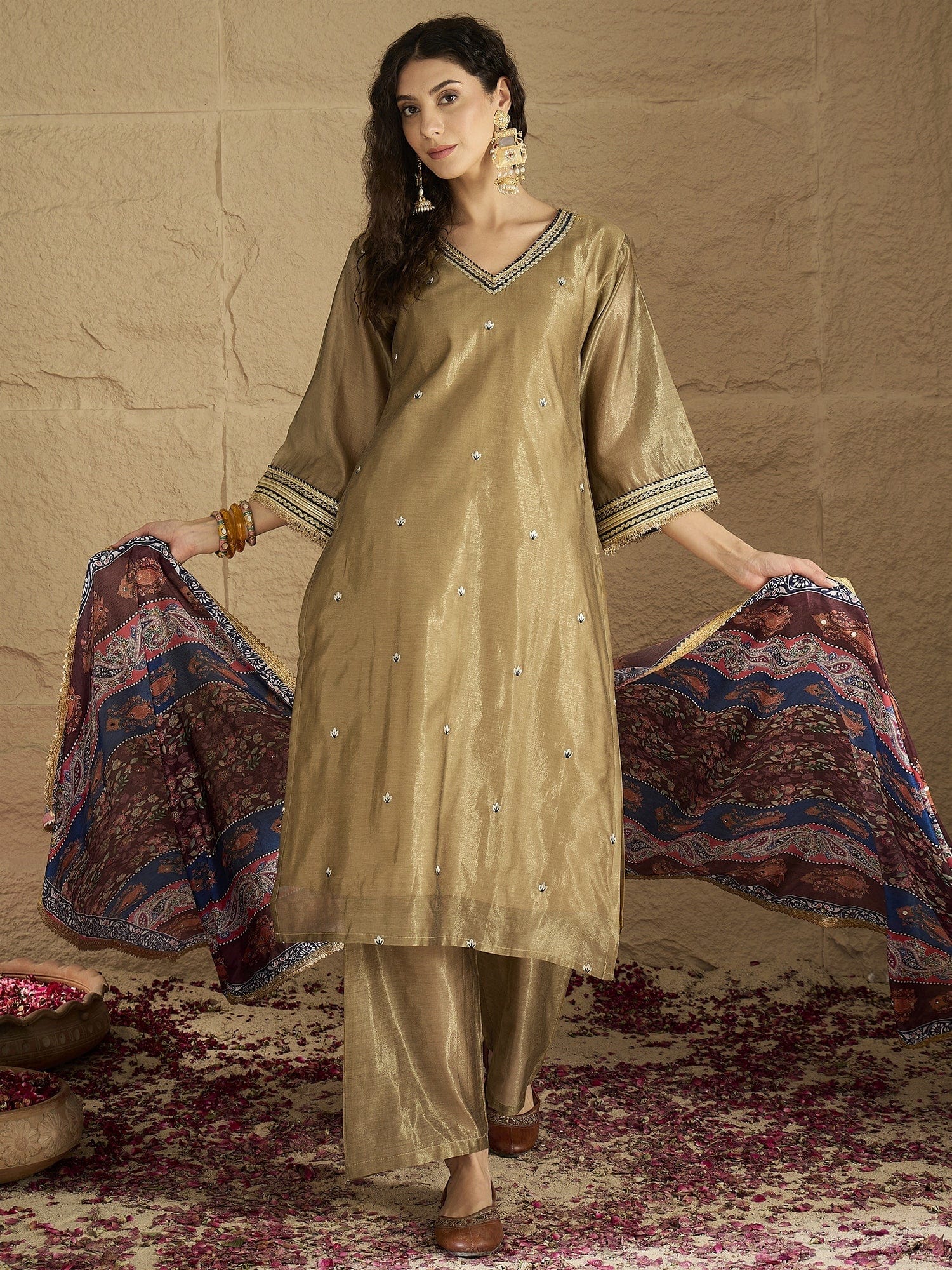 Varanga Women Radiate Festive Charm In This Gold Shimmer Kurta Set With Intricate Lace Detailing, Solid Ankle-Length Trousers, And  Printed Dupatta.