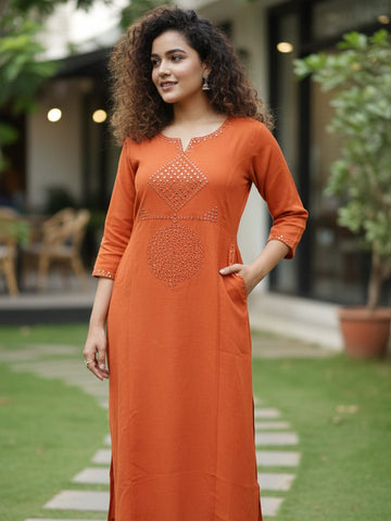 Orange kurta with mirror-detailed round neck paired with a matching trouser for a chic ethnic look.