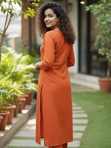 Orange kurta with mirror-detailed round neck paired with a matching trouser for a chic ethnic look.