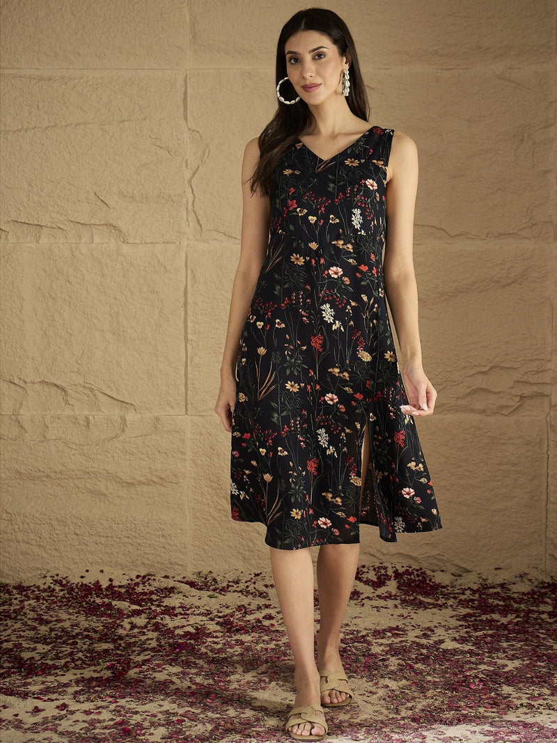 A Sleek Black Floral-Printed Knee-Length Dress With A V-Neckline And Side Slit Sleeveless, Stylish, And Perfect For Effortless Day-To-Evening Charm.