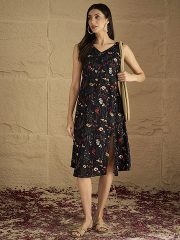 A Sleek Black Floral-Printed Knee-Length Dress With A V-Neckline And Side Slit Sleeveless, Stylish, And Perfect For Effortless Day-To-Evening Charm.