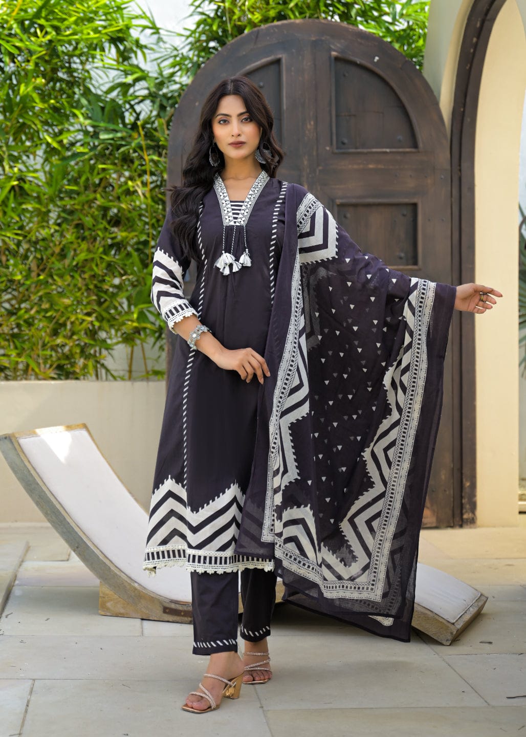 Varanga BLACK Placement Print A-Line Kurta Set. Featuring beautiful, strategically work and an elegant A-line silhouette. Enhanced with delicate thread and authentic mirror embroidery, complete with stylish tassel accents. Crafted for elegance and flair.
